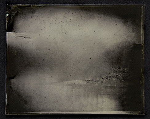 Panel C1: Landscape photo on glass. Silvery greys emerge from blacks to form passages of hard surfaces & insubstantial gases peppered /w black.