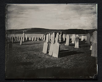 Panel B3 depicts a landscape full of tall, thin gravestones. Three in the foreground glow white from the sun. Rolling hills crown the distance.