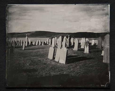 Panel B3 depicts a landscape full of tall, thin gravestones. Three in the foreground glow white from the sun. Rolling hills crown the distance.