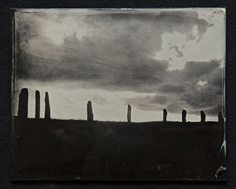 Panel C1 depicts a low landscape in silouette topped with monoliths surrounded by bright sky with dark rolling clouds above.